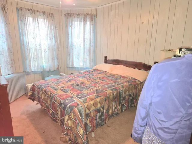 a bed sitting in a spacious bedroom next to a window