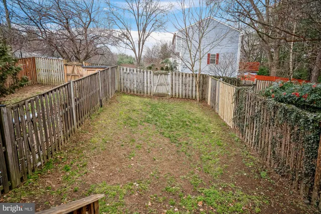 a view of backyard with wooden fence