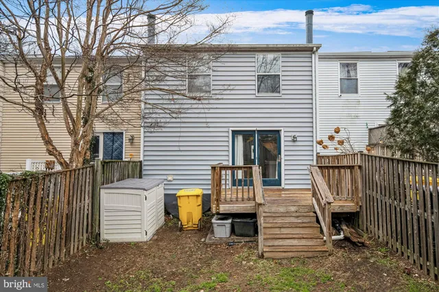 a view of a patio with table and chairs and wooden fence