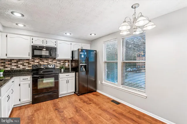 a kitchen with stainless steel appliances granite countertop a stove cabinets and refrigerator