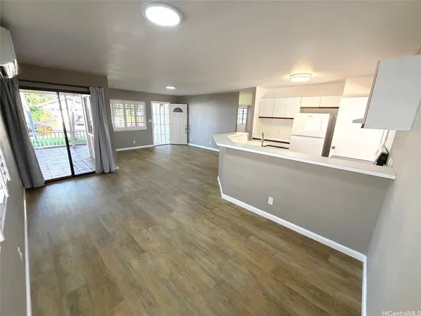 a view of a kitchen with wooden floor and electronic appliances