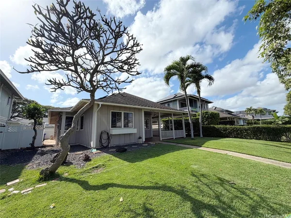a front view of a house with a garden and trees