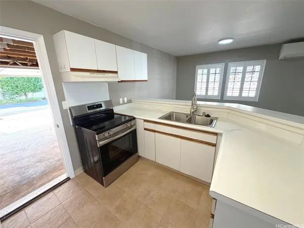 a kitchen with granite countertop a sink stove and cabinets