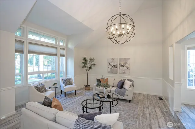 a living room with furniture a chandelier and a potted plant