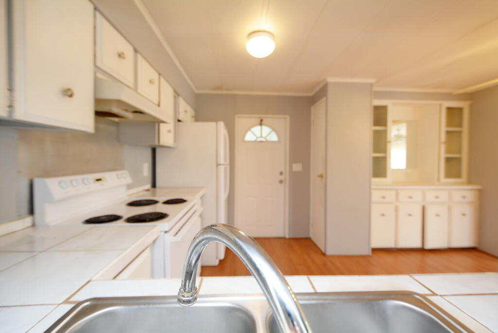 623 Periwinkle Circle Barefoot Bay, FL 32976 - Photo 11 of 37 a bedroom with a bed and a cabinets