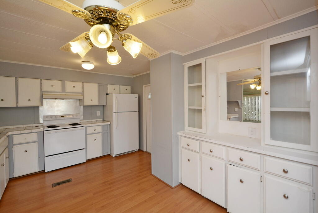 623 Periwinkle Circle Barefoot Bay, FL 32976 - Photo 12 of 37 a kitchen with cabinets a sink and stainless steel appliances