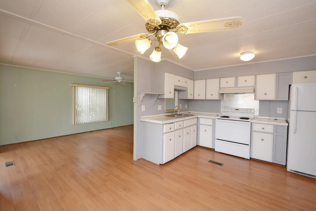 623 Periwinkle Circle Barefoot Bay, FL 32976 - Photo 14 of 37 a kitchen with a white cabinets and chandelier