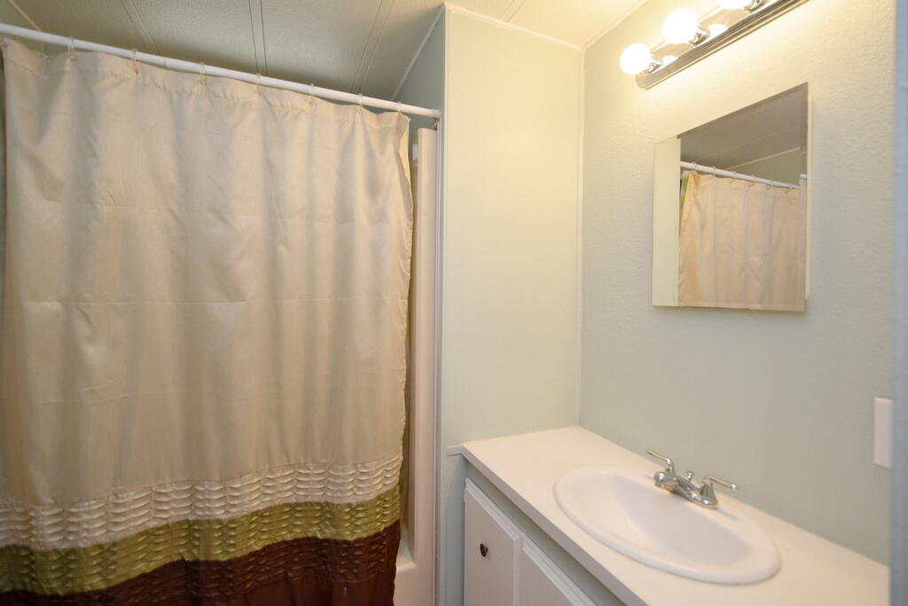 623 Periwinkle Circle Barefoot Bay, FL 32976 - Photo 17 of 37 a bathroom with a sink and a mirror