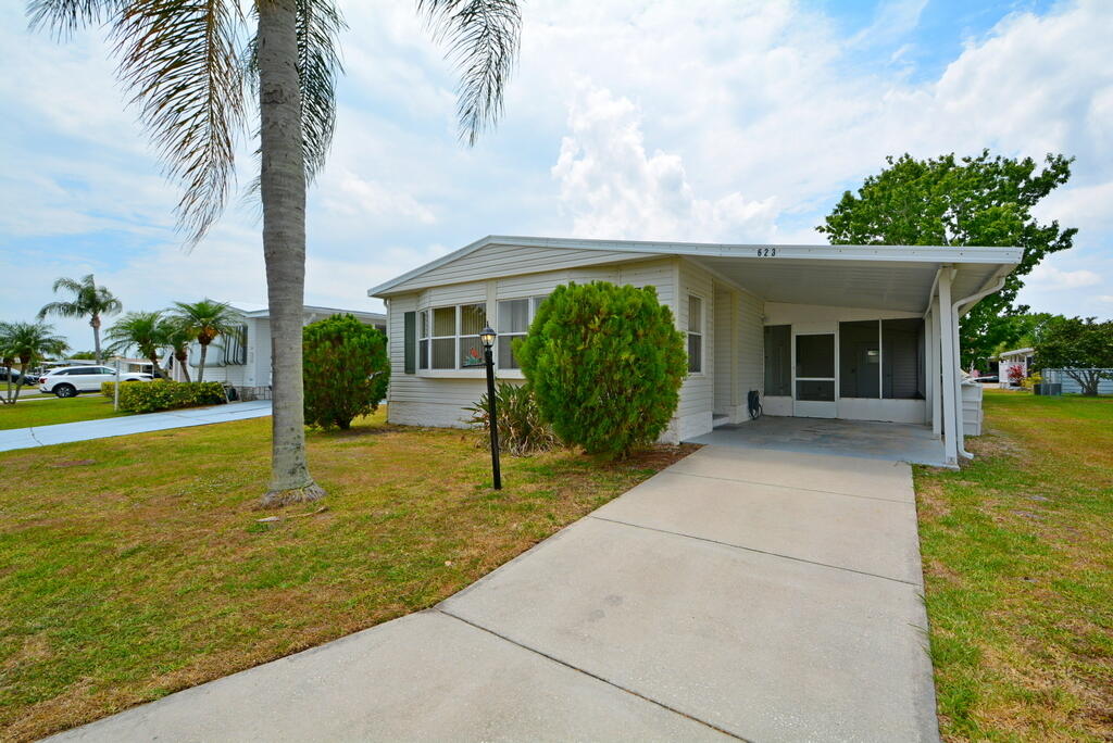 623 Periwinkle Circle Barefoot Bay, FL 32976 - Photo 2 of 37 a front view of a house with garden