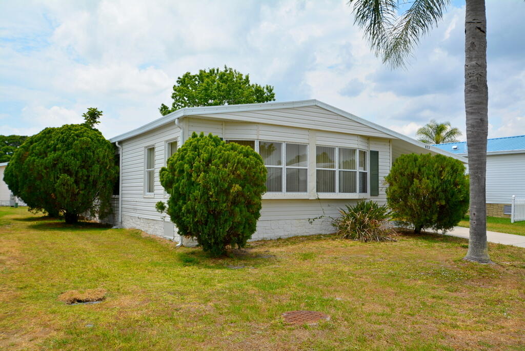 623 Periwinkle Circle Barefoot Bay, FL 32976 - Photo 3 of 37 a front view of a house with garden