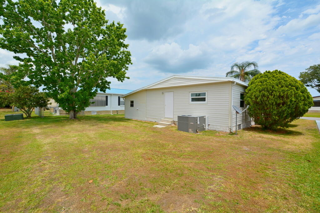 623 Periwinkle Circle Barefoot Bay, FL 32976 - Photo 36 of 37 a view of a house with a yard and garage