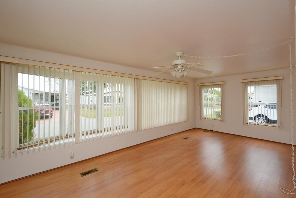 623 Periwinkle Circle Barefoot Bay, FL 32976 - Photo 6 of 37 a view of an empty room with wooden floor and a window