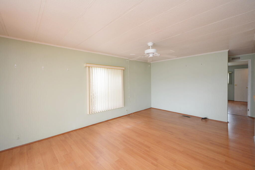 623 Periwinkle Circle Barefoot Bay, FL 32976 - Photo 9 of 37 a view of an empty room with wooden floor and a window