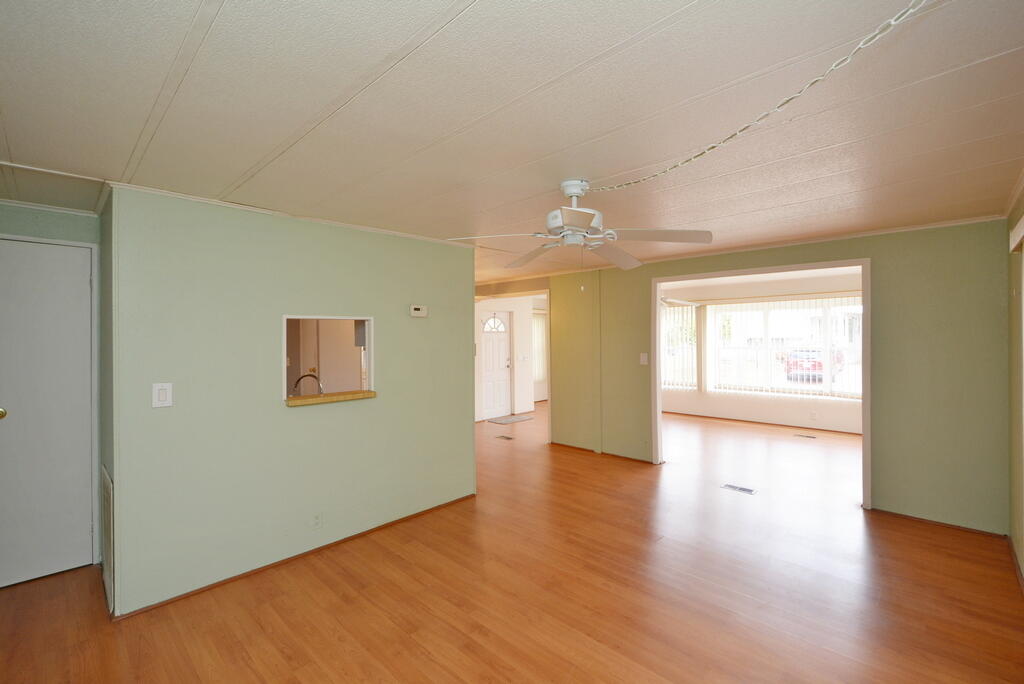 623 Periwinkle Circle Barefoot Bay, FL 32976 - Photo 10 of 37 an empty room with wooden floor and windows