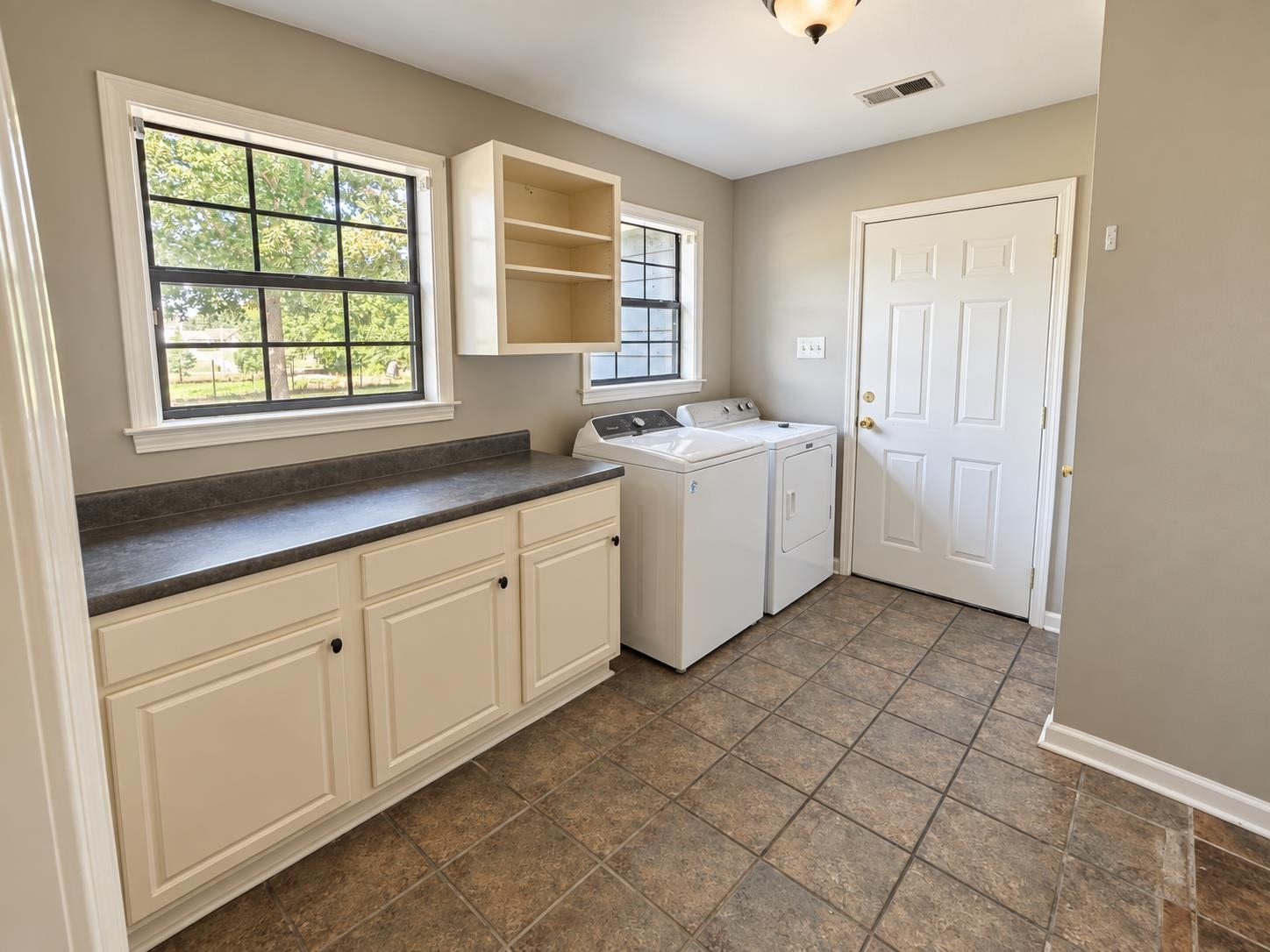 3771 West Union Road Millington, TN 38053 - Photo 7 of 16 Laundry room featuring tile flooring, built-in cabinetry, a countertop, and natural light from two windows