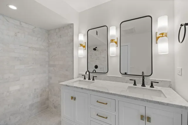 a bathroom with double vanity sinks and a mirror