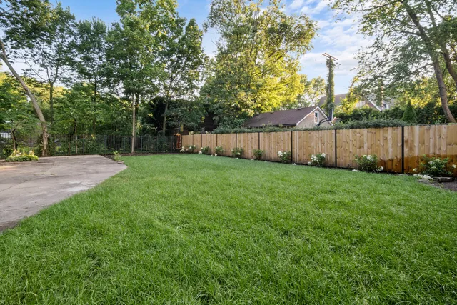 a view of a yard with wooden fence