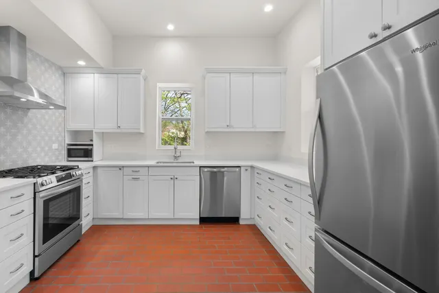 a kitchen with white cabinets and white appliances