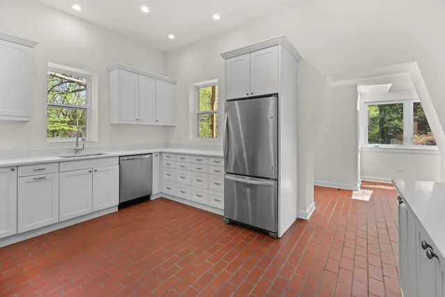 a kitchen with stainless steel appliances a refrigerator sink and cabinets