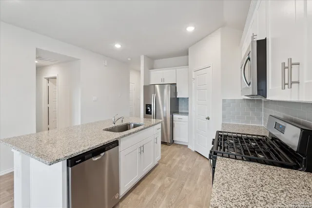 a kitchen with stainless steel appliances granite countertop a sink stove and refrigerator