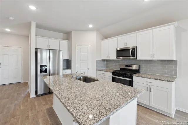 a kitchen with stainless steel appliances granite countertop a sink stove and refrigerator