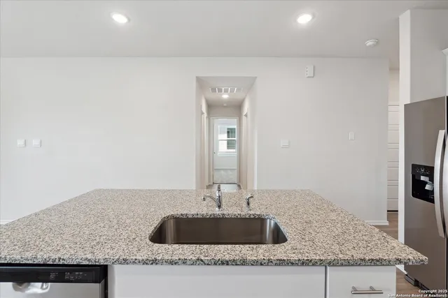 a bathroom with granite countertop a sink and a mirror