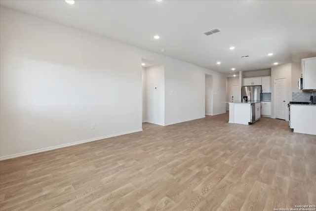 a view of empty room with wooden floor