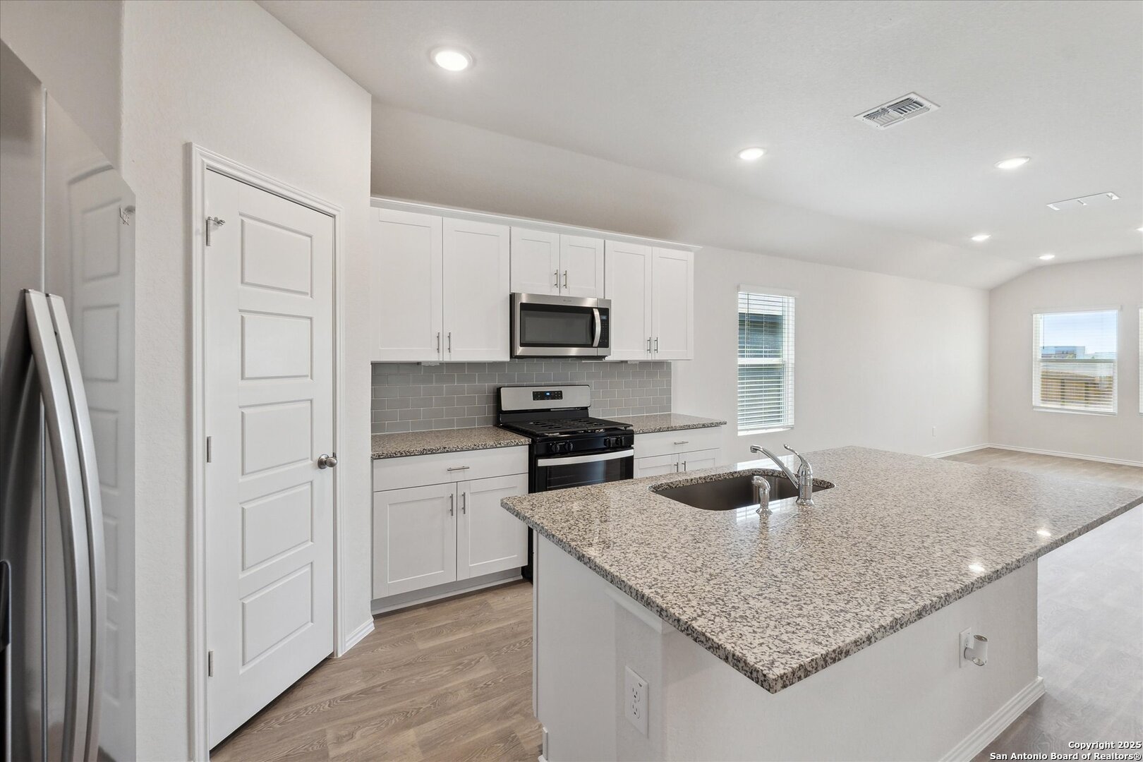 1632 Layne Loop New Braunfels, TX 78130 - Photo 10 of 34 a kitchen with stainless steel appliances granite countertop a refrigerator a stove and a sink