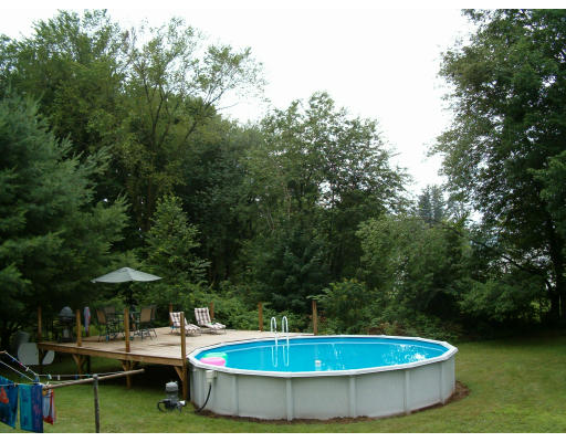 96 Anzio Road Athol, MA 01331 - Photo 8 of 8 a view of a swimming pool with lawn chairs under an umbrella