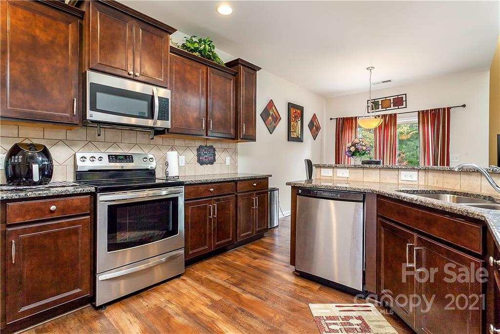 3016 Aransas Road Charlotte, NC 28214 - Photo 8 of 24 a kitchen with stainless steel appliances granite countertop a stove a sink dishwasher and a microwave oven with cabinets