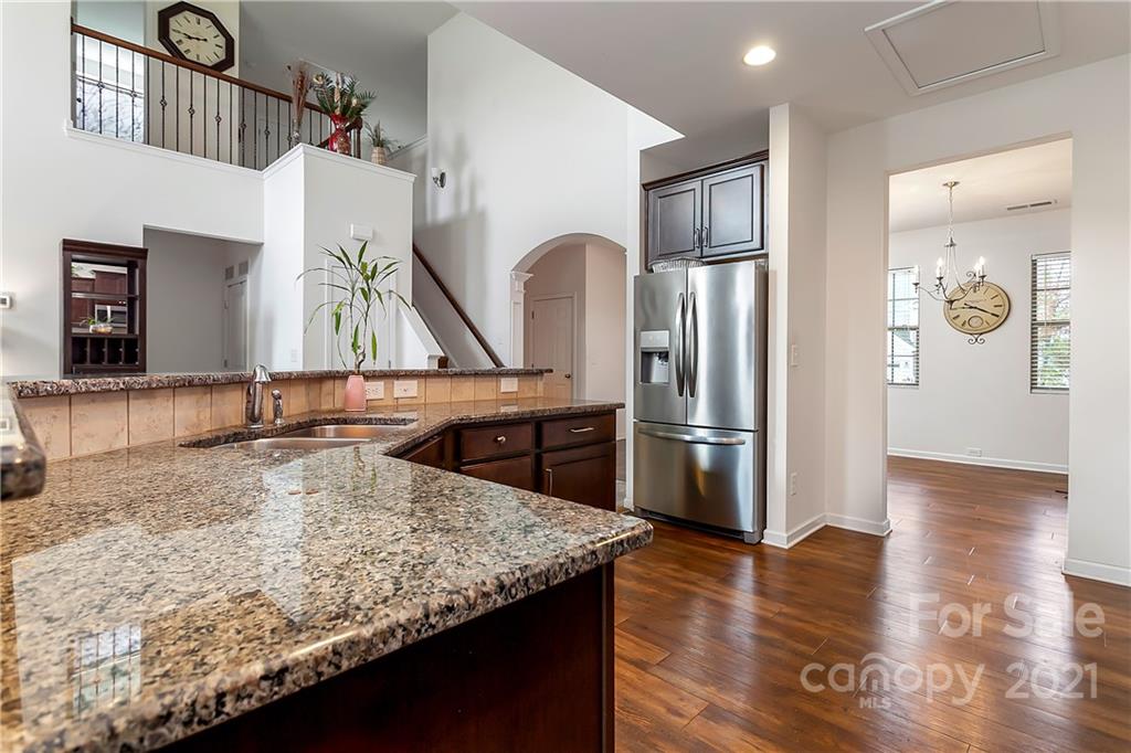 3016 Aransas Road Charlotte, NC 28214 - Photo 9 of 24 a kitchen with stainless steel appliances granite countertop a refrigerator a stove and a sink with wooden floor