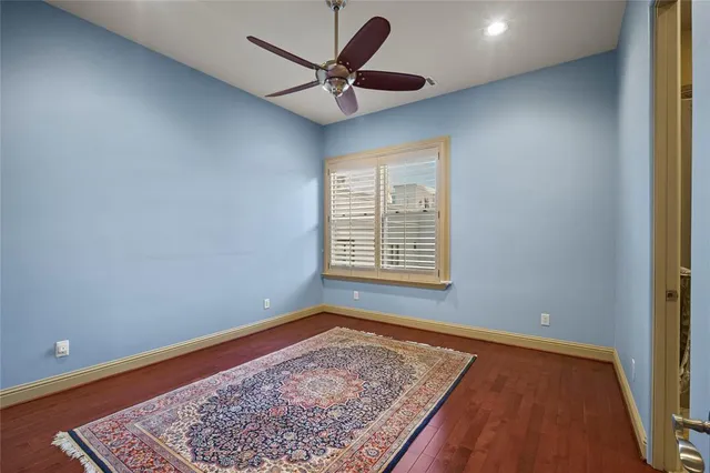 an empty room with a ceiling fan and a rug