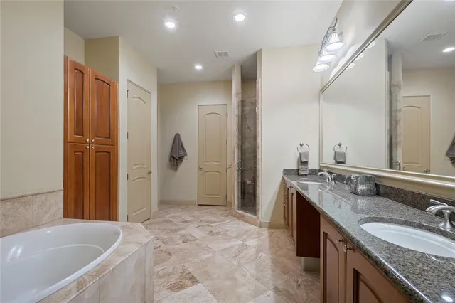 a bathroom with a granite countertop tub sink and mirror