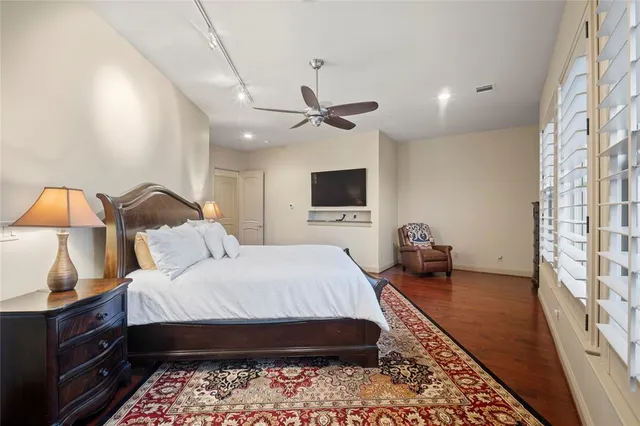 a bedroom with a bed a couch and a flat tv screen