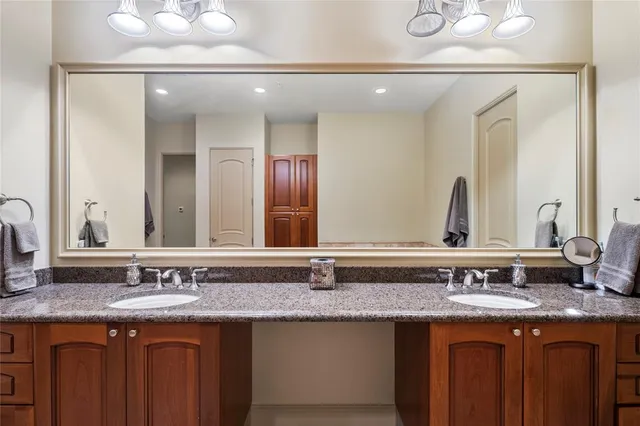 a bathroom with a granite countertop sink and a large mirror