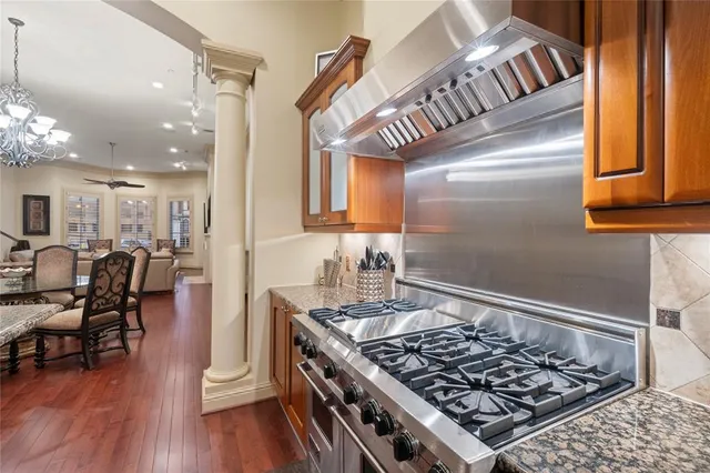 a kitchen with stainless steel appliances granite countertop a stove and a view of living room