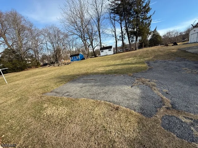 a front view of a building with large trees