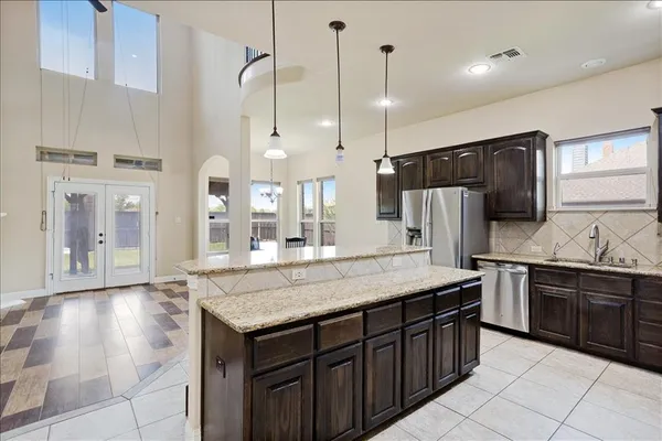a kitchen with granite countertop a stove refrigerator and cabinets