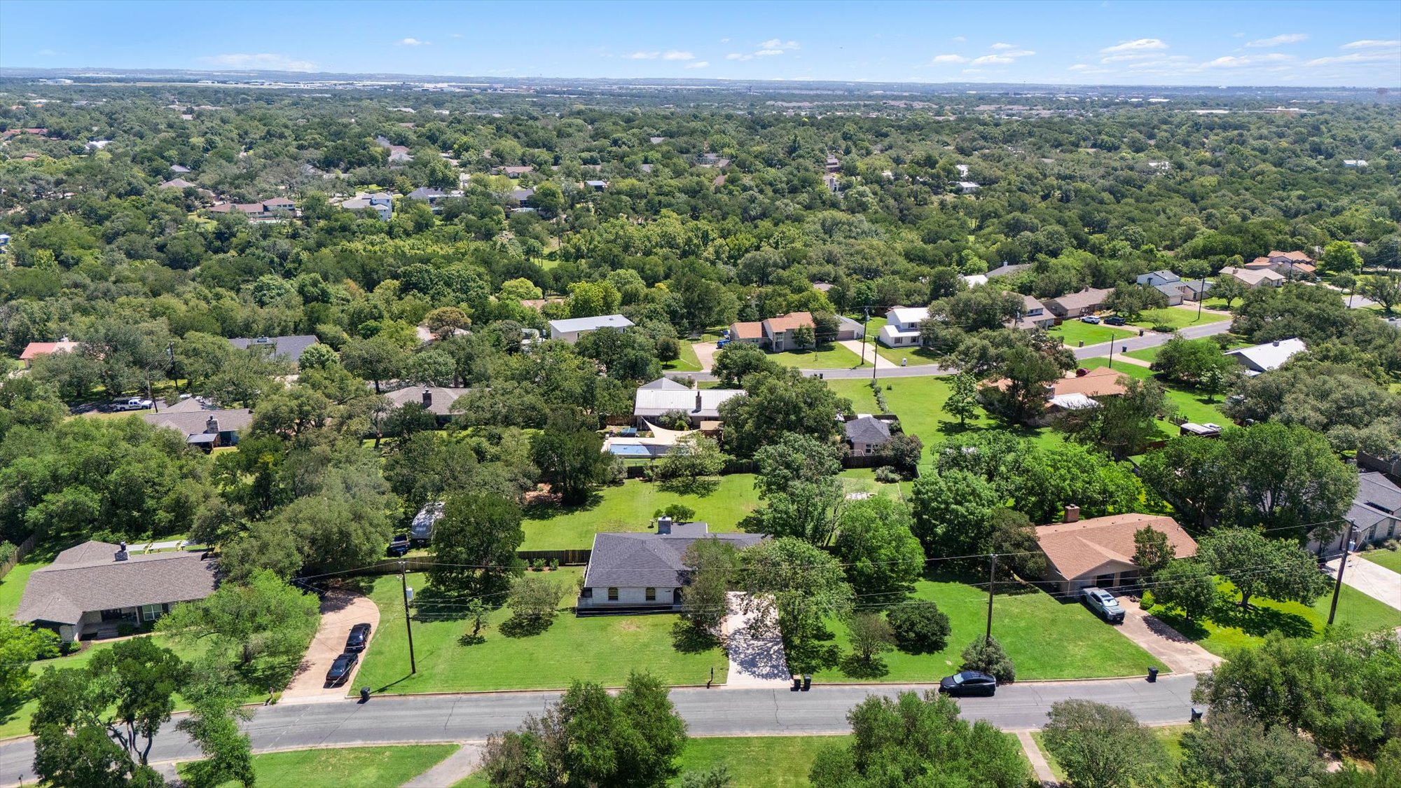 109 Woodland Road Georgetown, TX 78628 - Photo 7 of 40 An aerial perspective reveals a tree-lined neighborhood with well-maintained homes and verdant surroundings.