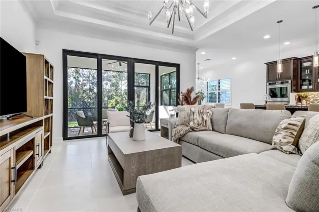 a living room with furniture a flat screen tv and a large window