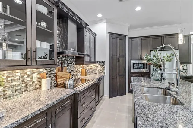 a kitchen with stainless steel appliances granite countertop a table chairs sink refrigerator and microwave