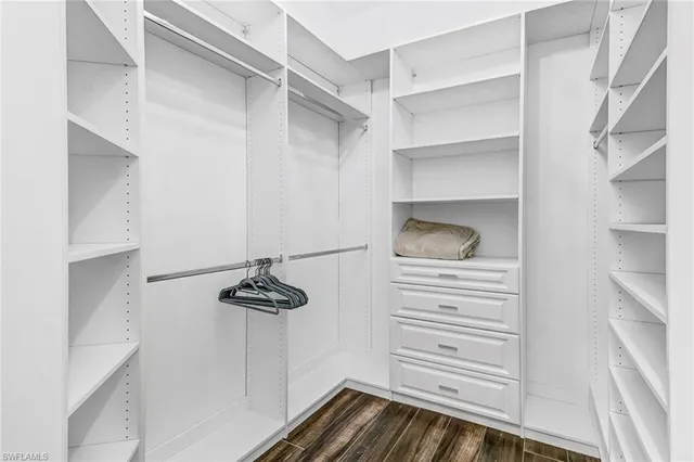 a walk in closet with white cabinets