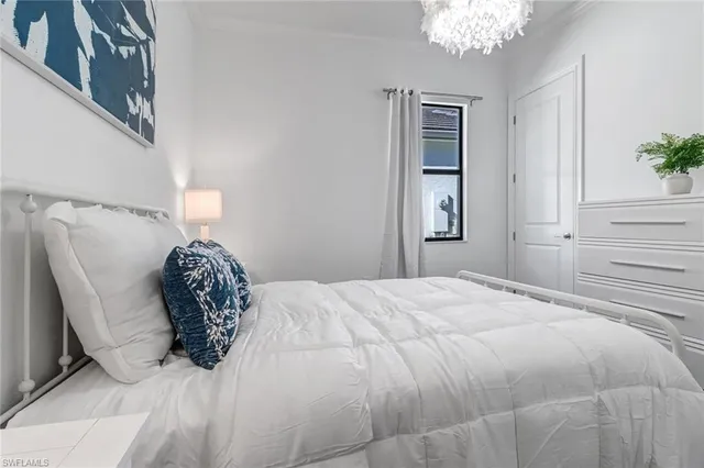 a bedroom with a bed and a chandelier