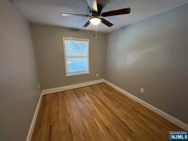 an empty room with a window and wooden floor