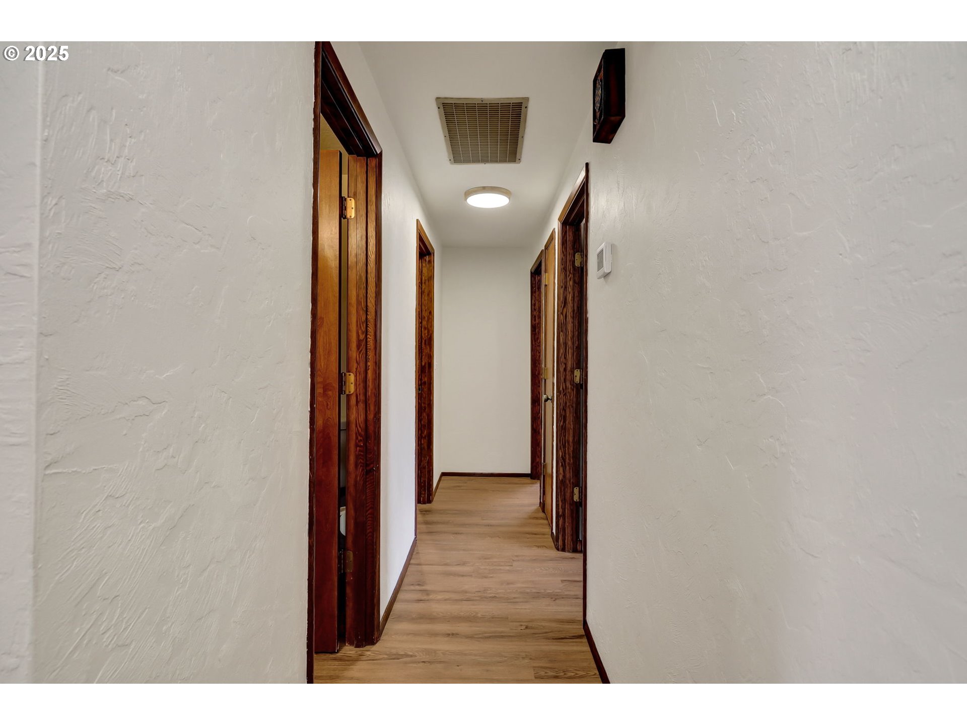 7087 Aster Street Springfield, OR 97478 - Photo 17 of 46 a view of a hallway with wooden floor