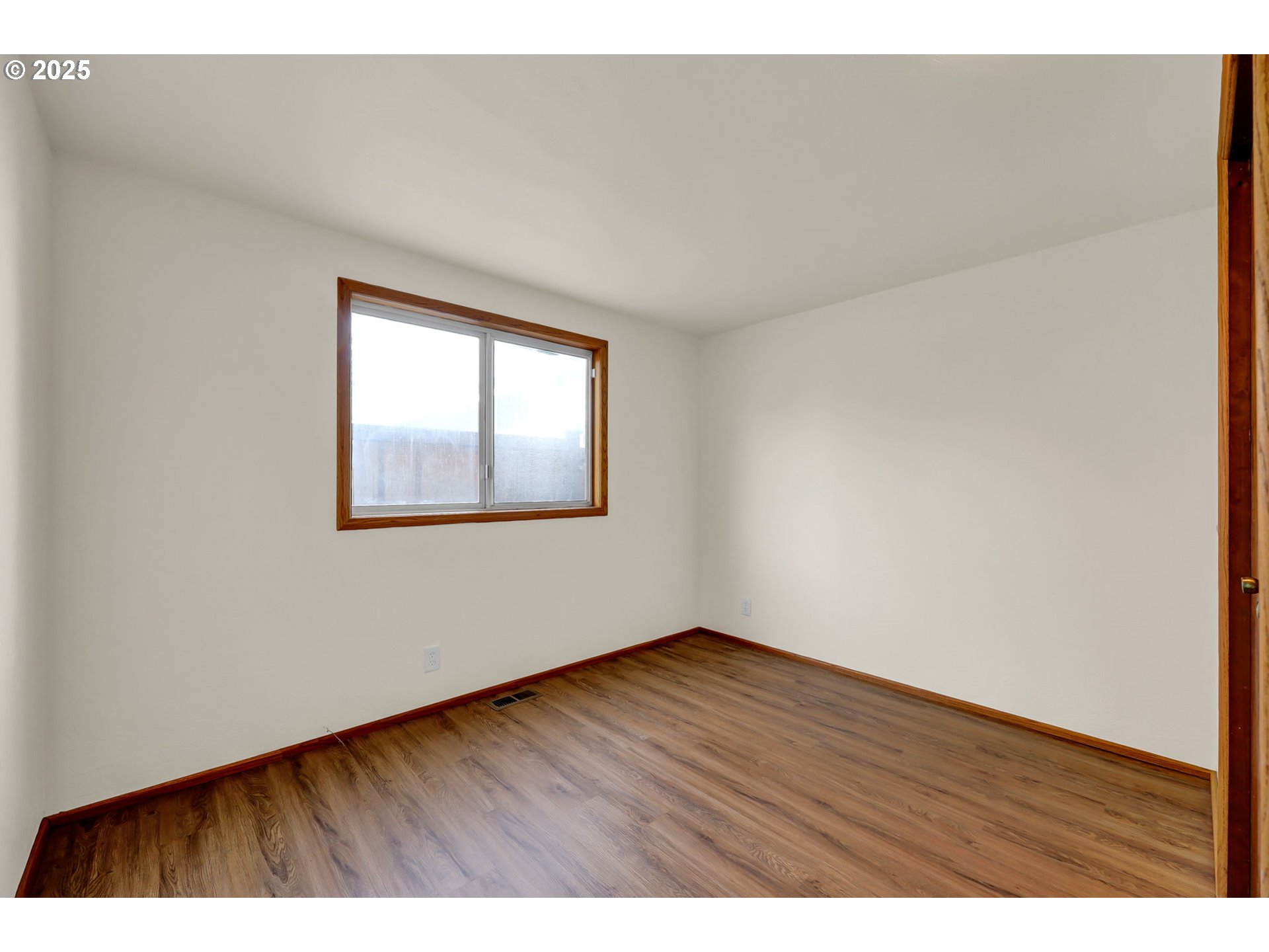 7087 Aster Street Springfield, OR 97478 - Photo 19 of 46 a view of an empty room with wooden floor and a window