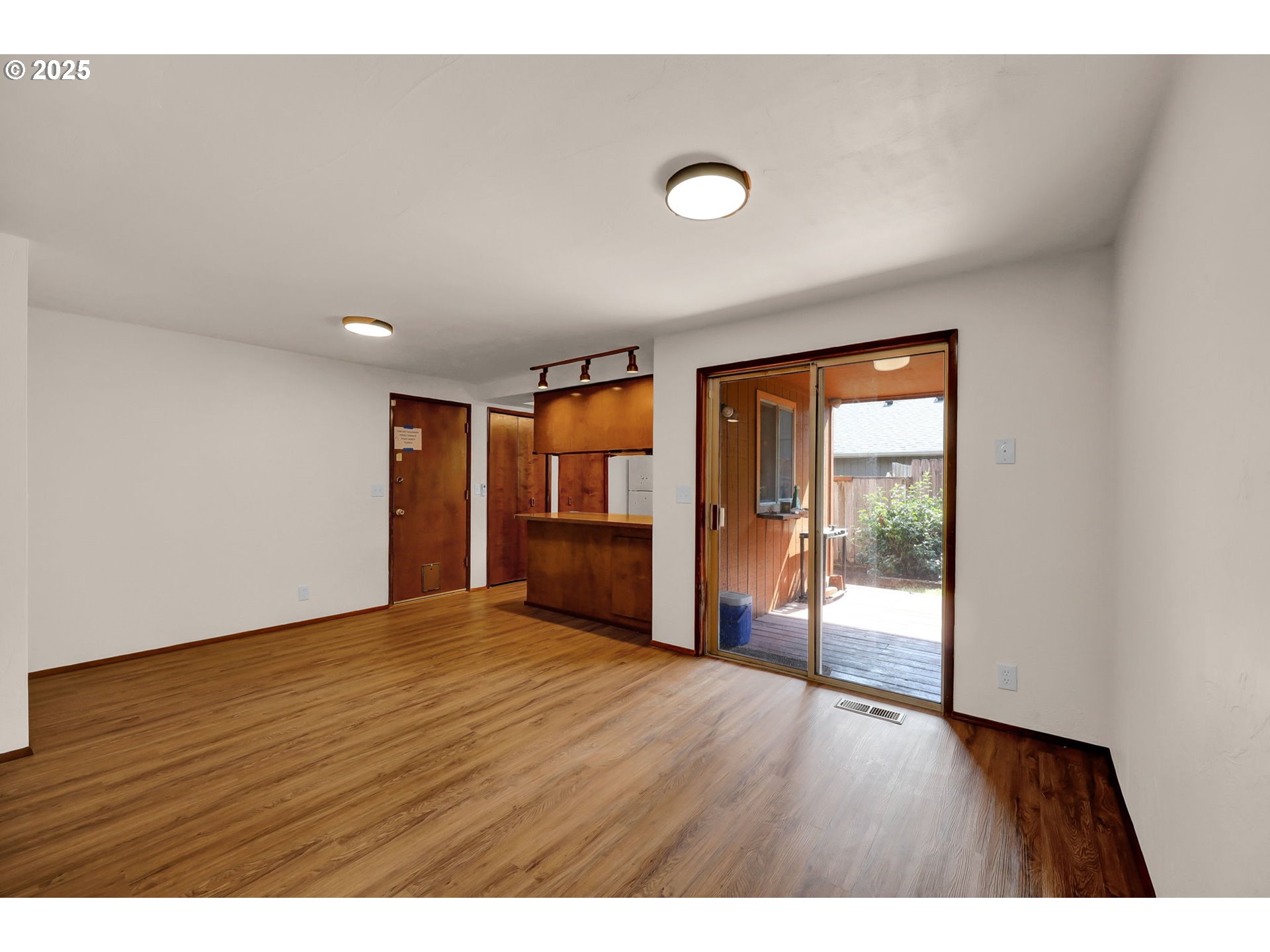 7087 Aster Street Springfield, OR 97478 - Photo 8 of 46 a view of an empty room with wooden floor and a window