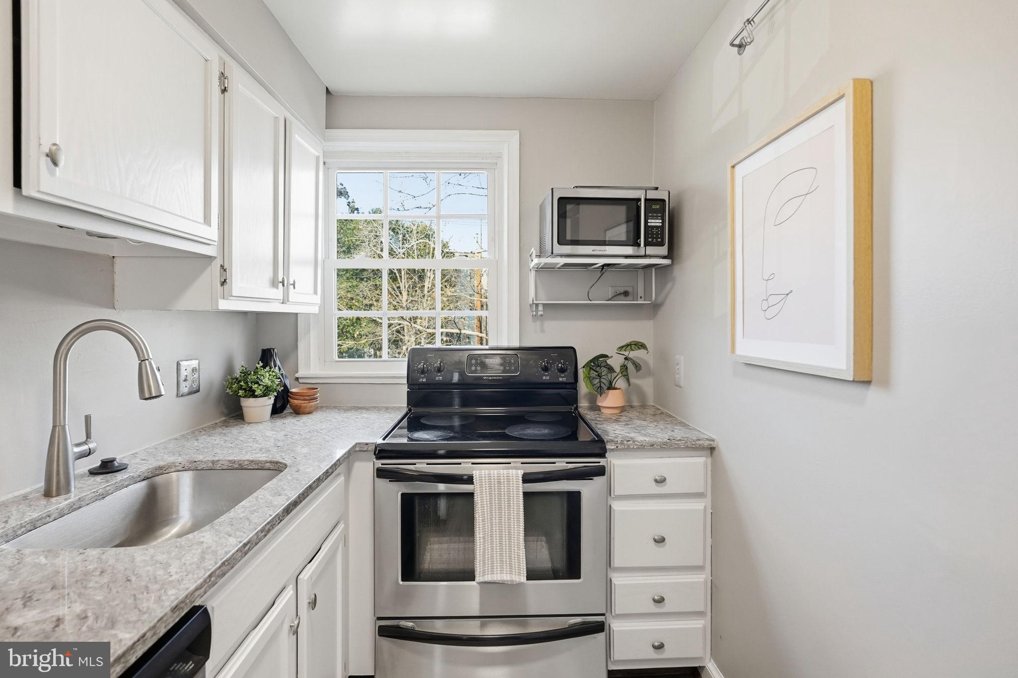 2900 13th Road South, Unit 201 Arlington, VA 22204 - Photo 15 of 32 a kitchen with granite countertop a sink stainless steel appliances and cabinets