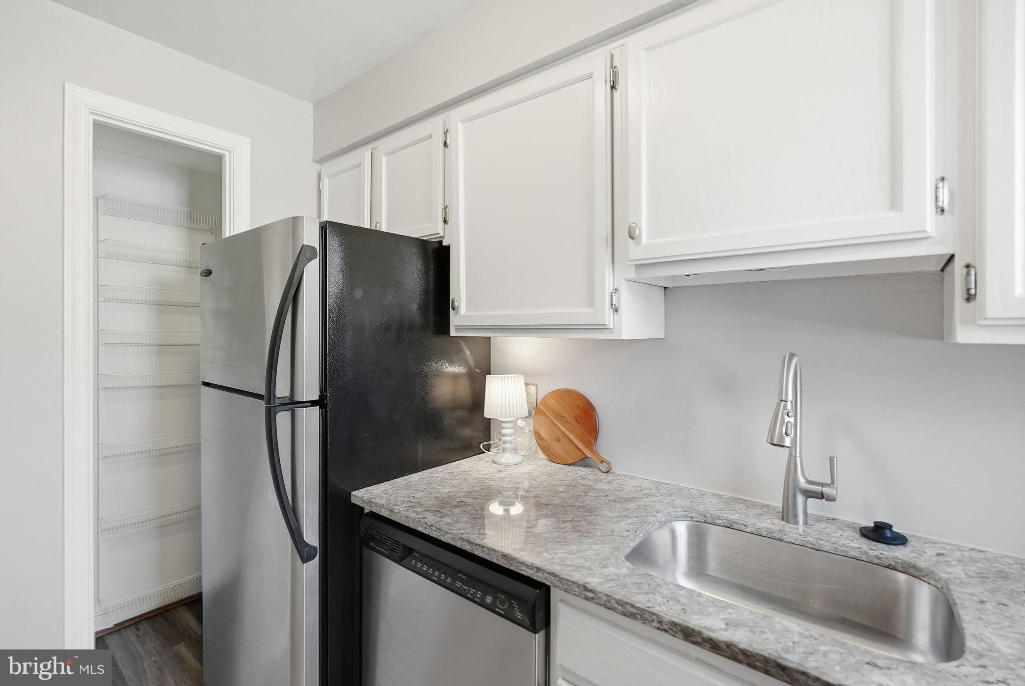 2900 13th Road South, Unit 201 Arlington, VA 22204 - Photo 16 of 32 a kitchen with stainless steel appliances granite countertop a refrigerator a sink and white cabinets