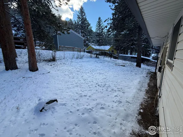 a view of a yard covered with snow in the backyard